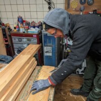 Ein Tischler stemmt Holz von einem Brett