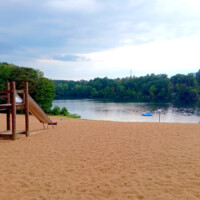Ein Strand am See inmitten eines Campingplatzes
