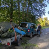 Ein Autoanhänger wird mit Heu beladen