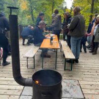 Ein Kocher mit Holzfeuerung steht auf einer Terrasse