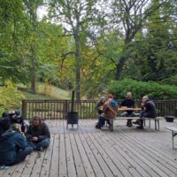 Menschen sitzen auf einer Terrasse und essen